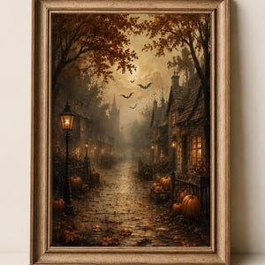 May include: A framed wall art print depicting a dark, atmospheric autumn street scene at twilight. The image features old stone houses, glowing street lamps, scattered fallen leaves on the ground, orange pumpkins, and silhouettes of bats in the sky.