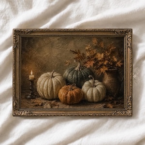 May include: A rectangular framed wall art piece featuring a still life painting of three pumpkins in shades of white, green, and orange, a lit candle in a dark metal holder, and a ceramic jug filled with autumn leaves in a muted, earthy color palette.