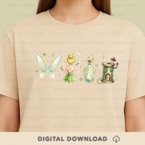 以下が含まれることがあります： ベージュ色のTシャツ。妖精、羽、ポーションボトル、キノコの屋根の小さな家が描かれたファンタジーイラスト。下部には「DIGITAL DOWNLOAD」の文字がプリントされています。