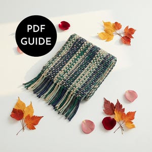 May include: A patterned scarf in green, blue, and cream with a checkered design and fringed edges. The image includes autumn leaves and rose petals. The text "PDF GUIDE" is in a black circle.