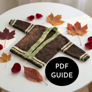 May include: A brown knitted cardigan with green trim and white stripes on the sleeves. The text "PDF GUIDE" is in a black circle. Autumn leaves and rose petals are scattered around the cardigan on a white surface.