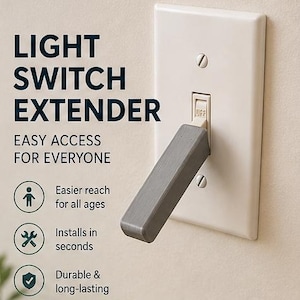 Könnte beinhalten: Ein grauer Lichtschalterverlängerer an einer weißen Wandplatte. Der Text auf dem Bild lautet "LIGHT SWITCH EXTENDER EASY ACCESS FOR EVERYONE". Der Verlängerer ist für eine einfachere Reichweite konzipiert und lässt sich in Sekundenschnelle installieren.
