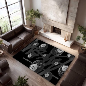May include: Black rectangular rug with a design of stylized eight-balls and grey lines. The eight-balls have a white eight symbol. The rug is in a living room with brown leather furniture and a fireplace.