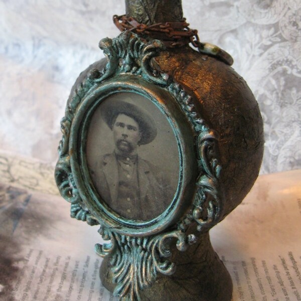 On the Shoulders of His Ancestor.  An altered art bottle with tintype, antique doll head, heavy metal crown