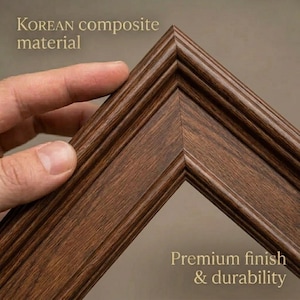 May include: Close-up of a corner of a brown wooden picture frame. The frame is made of Korean composite material and has a premium finish. The text "Premium finish & durability" is visible.