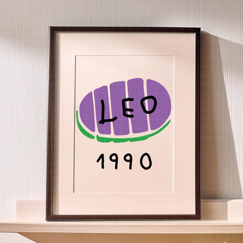 May include: Framed art print featuring a purple oval design with the word "LEO" in black letters, and the number "1990" below. The design is set against a white background, framed in a dark brown frame.