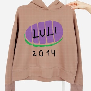 May include: A tan hoodie with a purple and green graphic that reads "LULI" above the number "2014" in black. The hoodie has a hood and long sleeves.