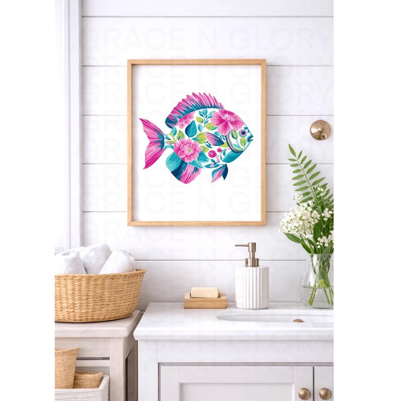 May include: A framed art print featuring a colorful fish design. The fish is adorned with pink and blue floral patterns, set against a white background. The artwork is displayed in a light brown wooden frame, suitable for bathroom decor.