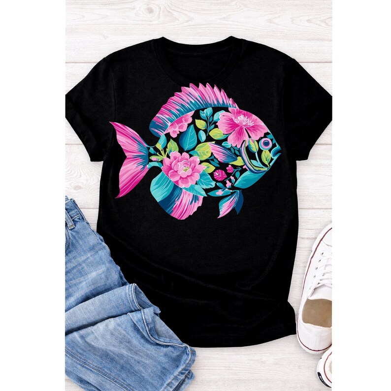 May include: Black t-shirt featuring a colorful fish design. The fish is adorned with pink flowers, teal and blue accents, and green leaves. The fish's tail and fins are pink. The shirt is paired with blue jeans and white sneakers.