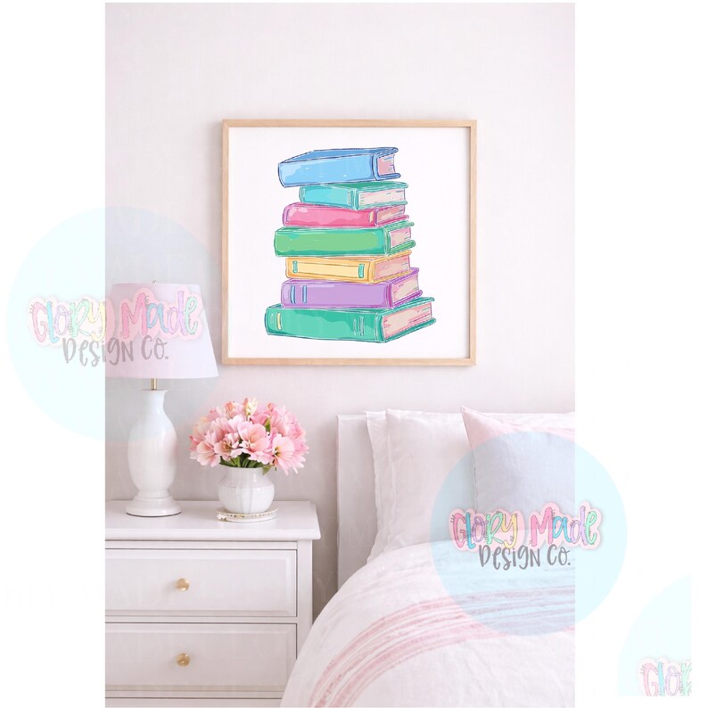 May include: A framed print featuring a stack of colorful books. The books are in shades of blue, pink, green, yellow, and purple. The artwork has a watercolor style and is displayed in a bedroom setting with a white nightstand, lamp, and pink flowers.
