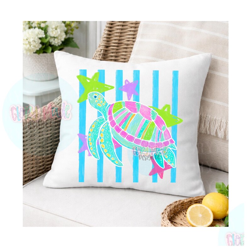 May include: A white square throw pillow featuring a colorful sea turtle illustration centered over vertical light blue stripes. The turtle shell displays vibrant pink, green, and yellow patterns, surrounded by small lime green and purple stars.
