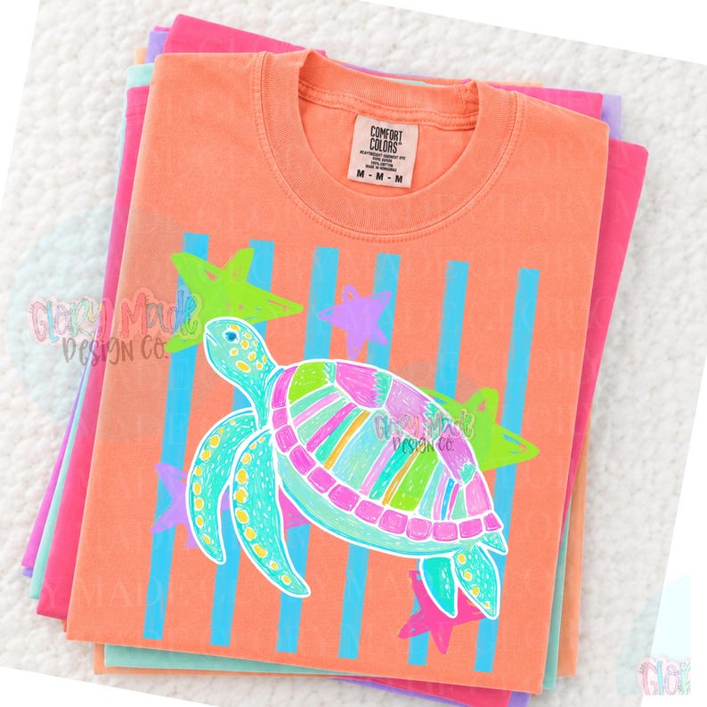 May include: A peach-colored crew neck t-shirt with a Comfort Colors label at the collar. The graphic features a multi-colored sea turtle in shades of pink, green, and blue, set against a background of vertical blue stripes and several star shapes.