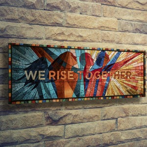 May include: A rectangular wall art piece featuring a stained glass style design with abstract figures in shades of blue, orange, red, and yellow. The text WE RISE TOGETHER is printed in a bold, sans-serif font across the centre of the artwork.