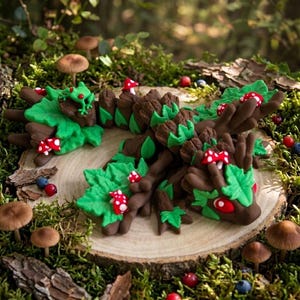 Peut inclure: Une figurine de créature sculptée marron et verte avec un long corps texturé orné de feuilles vert vif et de petits champignons rouges à pois blancs. Une petite grenouille verte est posée sur le dos de la créature aux grands yeux rouges.