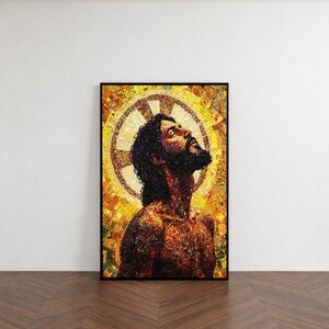 Könnte beinhalten: Ein gerahmter Mosaik-Kunstdruck, der einen Mann mit dunklem Haar und Bart zeigt, der nach oben blickt. Das Kunstwerk zeigt einen goldenen Heiligenschein und einen Mosaikstil mit warmen Tönen von Gelb, Orange und Braun. Der Druck wird an einer weißen Wand ausgestellt.