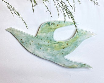 Hand glazed ceramic hanging bird decoration, with glazes in shades of green , olive and yellow