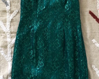 May include: A green sequined lace dress with a criss-cross strap back.