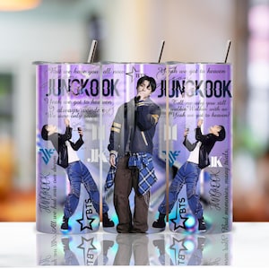 Könnte beinhalten: Ein Edelstahlbecher mit einem Design mit dem Namen "JUNGKOOK" und Bildern einer Person. Der Becher hat einen lila Hintergrund mit Songtexten und dem BTS-Logo. Er enthält einen silbernen Strohhalm.