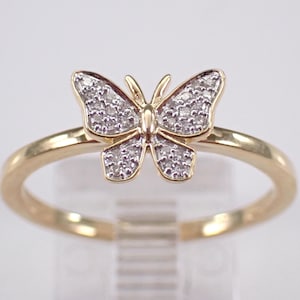 May include: A gold ring featuring a butterfly design with small diamonds.