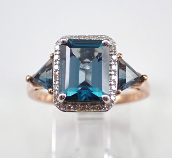 Emerald Cut Blue Topaz Engagement Ring - Rose Gold Diamond Halo Setting - Trillion Shape Sides Three Stone Ring