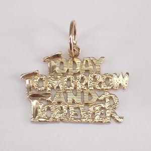 Könnte beinhalten: Ein goldfarbener Anhänger mit den Worten "TODAY TOMORROW AND FOREVER" in einer stilisierten Schriftart. Der Anhänger hat oben eine Schlaufe für eine Kette. Der Schmuck ist wahrscheinlich aus Gold oder einem goldfarbenen Metall gefertigt.