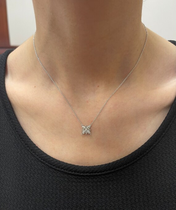 Premium AI Image | A gold snowflake necklace with a diamond pendant on a  blue background.