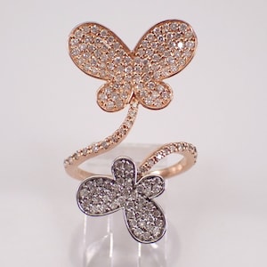 May include: A rose gold ring with two butterfly designs. The top butterfly is larger and has a swirl design leading to the smaller butterfly below. Both butterflies are covered in small diamonds.