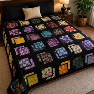 May include: A bed quilt featuring a grid of square patches with various floral patterns in shades of yellow, purple, blue, and red, separated by solid black fabric borders. The quilt has a thin pink edge trim and covers the entire bed surface.