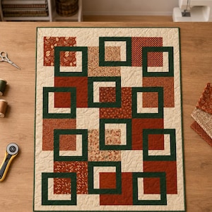 May include: A rectangular quilt featuring a geometric pattern of interlocking dark green squares on a cream background with various rust, orange, and brown floral and polka dot fabric blocks. The quilt has a dark green border and quilted texture.