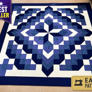 May include: A large, geometric quilt in shades of blue and white. The quilt features a central starburst design and a border of solid navy blue. The words "BEST SELLER" and "EASY PATTERN" are visible.