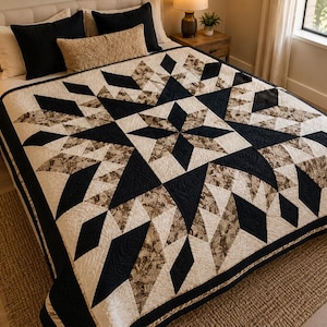 May include: A quilt featuring a large central star pattern composed of solid black fabric, cream fabric, and brown floral patterned fabric. The geometric design consists of diamonds and triangles arranged in a symmetrical layout with intricate stitching.
