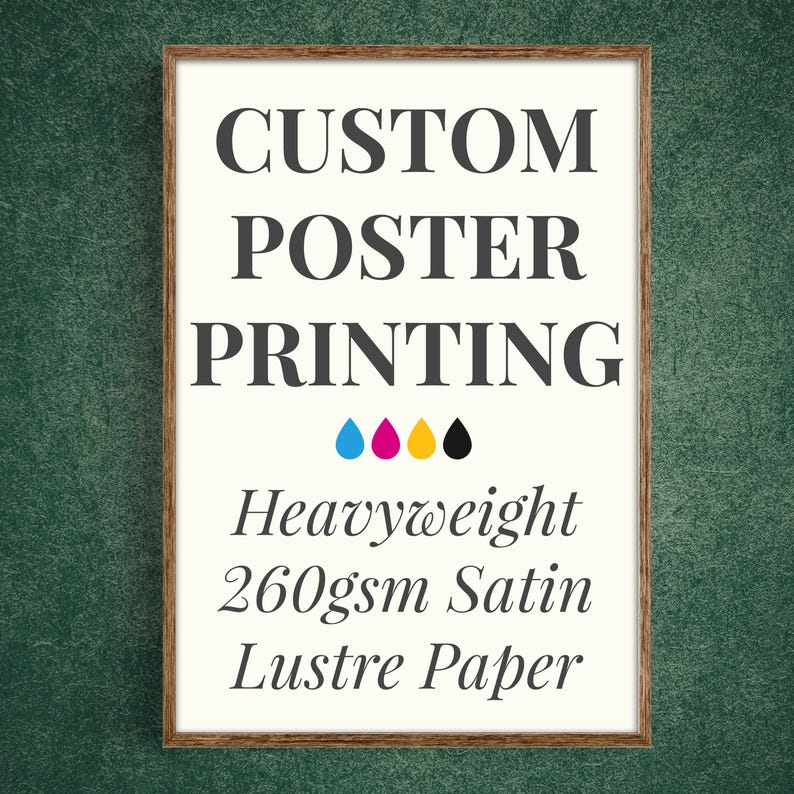 May include: A rectangular poster in a brown wooden frame with white background and dark gray text reading CUSTOM POSTER PRINTING, followed by four colored ink drops in cyan, magenta, yellow, and black, and text Heavyweight 260gsm Satin Lustre Paper.