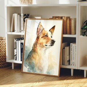 May include: A framed watercolor-style art print featuring a portrait of a tan and white dog with pointed ears, looking toward the right. The artwork uses soft washes of blue and brown tones against a light background, encased in a light wood frame.