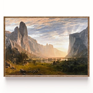 Pode incluir: Uma pintura de paisagem emoldurada retrata uma cena de vale com formações rochosas imponentes e um rio. A obra apresenta uma paleta de cores quentes com luz solar dourada. A moldura é de madeira.