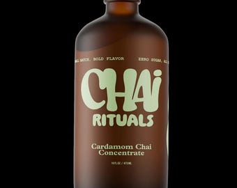 Puede incluir: Una botella de vidrio marrón con tapa plateada, etiquetada "Chai Rituals" en verde claro. La botella contiene Concentrado de Chai de Cardamomo, 473 ml. También se ve el texto "Batch, Bold Flavor" y "Zero Sugar, All".