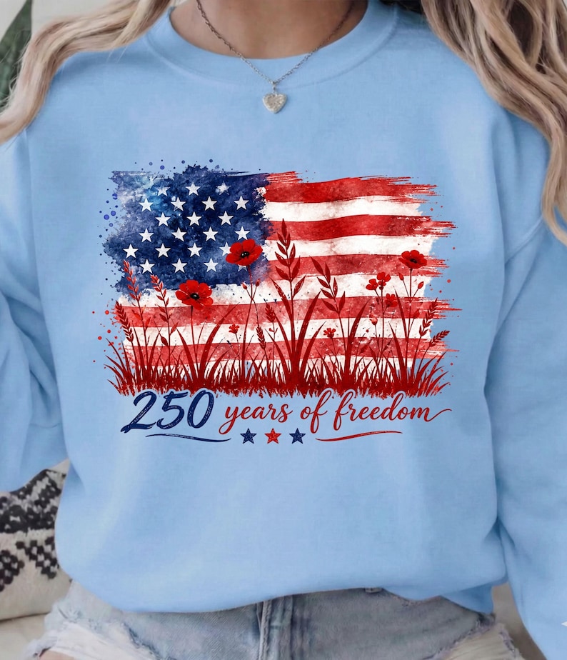 Patriotic floral USA flag PNG graphic displayed on a colorful pastel blue sweatshirt mockup.