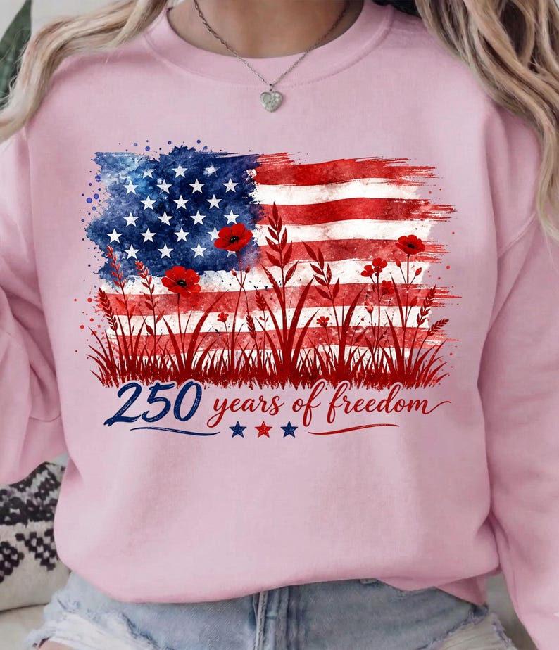 Patriotic floral USA flag PNG graphic displayed on a colorful pastel pink sweatshirt mockup.