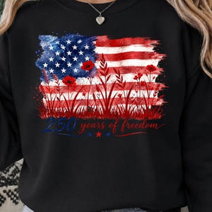Patriotic floral USA flag PNG graphic displayed on a colorful pastel black sweatshirt mockup.