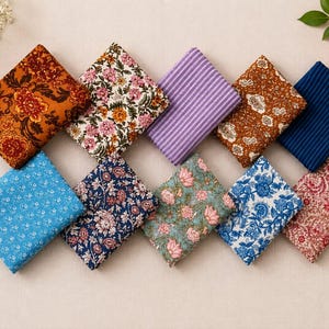 May include: Ten folded fabric squares featuring various patterns including floral prints in orange, pink, blue, and green, alongside purple and navy blue striped designs. The collection displays a diverse range of colors and intricate botanical motifs.