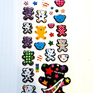 May include: Sheet of colorful bear stickers in various patterns and colors, including green plaid, pink polka dots, and yellow. One large black bear sticker has the text "You are my star" and "BE HAPPY!"