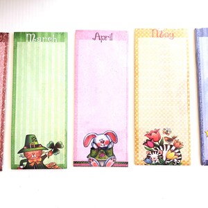 May include: A set of five decorative bookmarks, each featuring a different month: February, March, April, May, and June. Each bookmark has a unique background pattern and a cartoon illustration of a cat, leprechaun, bunny, flowers, and a dog.