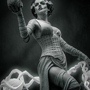 May include: A black and white figurine of a figure with dark hair, wearing a corset and a skirt, with arms and legs wrapped in bandages. The figure holds a skull in one raised hand and stands amidst swirling white energy effects on a dark base.