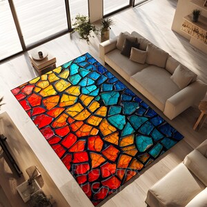 Könnte beinhalten: Ein rechteckiger Teppich mit abstraktem Design. Der Teppich hat ein mosaikartiges Muster mit einem Farbverlauf, der von Rot über Orange und Gelb zu Blau verläuft. Er liegt auf einem hellen Holzboden.
