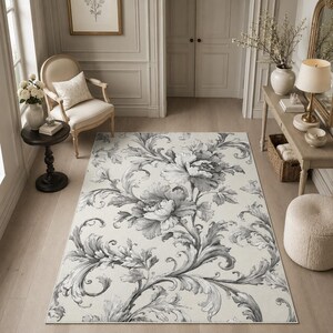 May include: A rectangular area rug featuring a large-scale floral and scrolling acanthus leaf pattern in shades of charcoal gray and black set against a cream-colored background, creating a high-contrast botanical design for floor coverage.