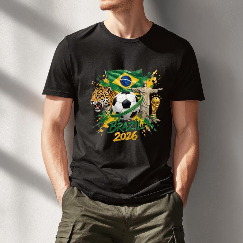 May include: Black t-shirt featuring a soccer ball, the Brazilian flag, the Christ the Redeemer statue, and a jaguar. The shirt also includes the text "BRAZIL 2026" in yellow and green, with a gold trophy.