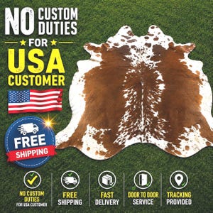 Op de afbeelding: Een bruin en wit koeienhuidkleed met een onregelmatige vorm, weergegeven op groen gras. Het kleed heeft een natuurlijk patroon van bruine en witte vlekken. De tekst in de afbeelding luidt "NO CUSTOM DUTIES FOR USA CUSTOMER" en "FREE SHIPPING".
