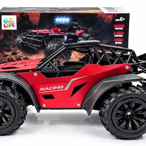 May include: A red and black remote-controlled racing buggy with large treaded tires, a roll cage, and a rear spoiler. The vehicle features the word RACING on the side panel and is positioned in front of its original product packaging box.