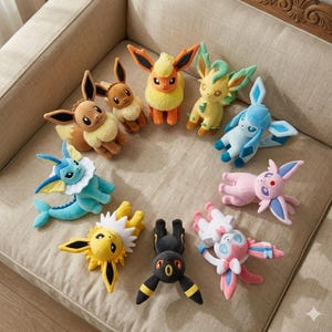 May include: A selection of plush Pokémon figures in a variety of colours, including brown, yellow, blue, pink, and black. The toys are arranged in a circle on a beige sofa. Each figure has unique features.