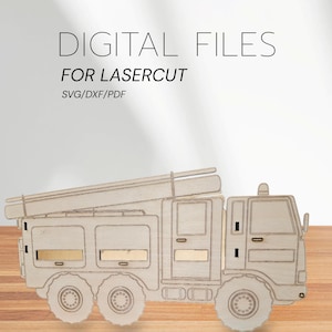 Könnte beinhalten: Ein Holzmodell eines Feuerwehrautos mit Leiter, Rädern und rechteckigen Fenstern. Der Text "DIGITAL FILES FOR LASERCUT SVG/DXF/PDF" ist oben zu sehen. Das Modell ist aus hellem Holz gefertigt.