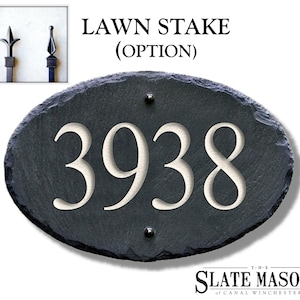 May include: Oval slate house number sign with the number 3938 engraved in white. The sign is attached to a black metal lawn stake with a decorative finial. The sign is made by The Slate Masons of Canal Winchester.